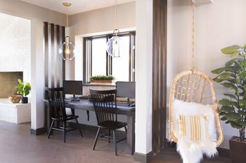 a dining area with a table and chairs and a hanging chair at The Timbers Apartments, Evansville, IN